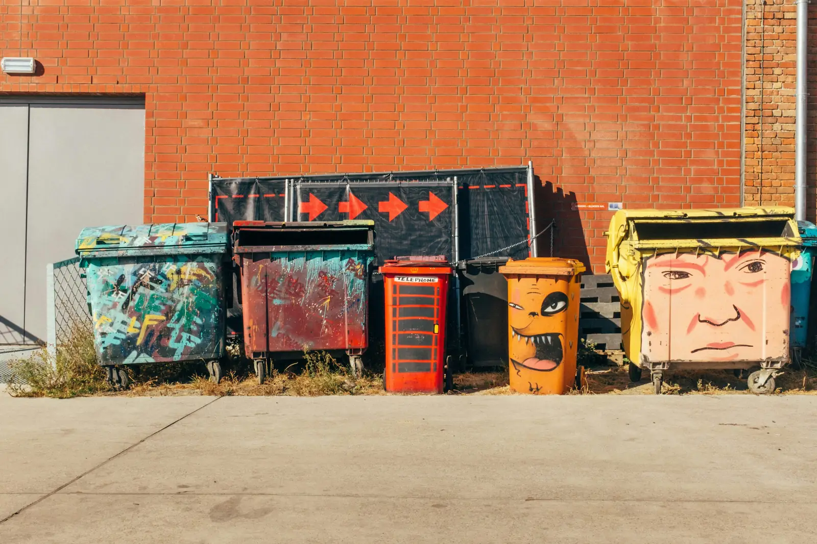 Wheelie bins against a brick wall