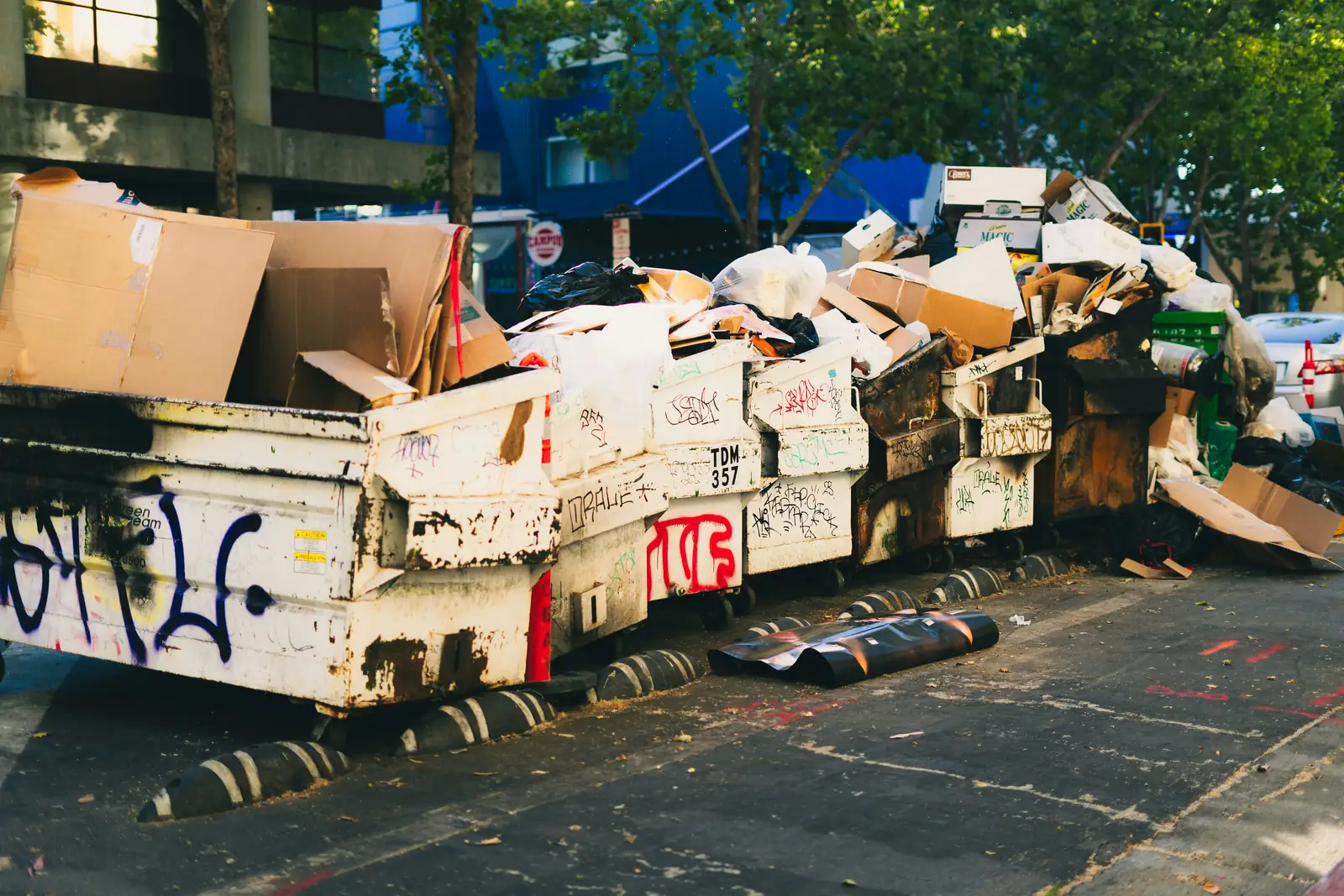 Overflowing bins and cardboard on a street